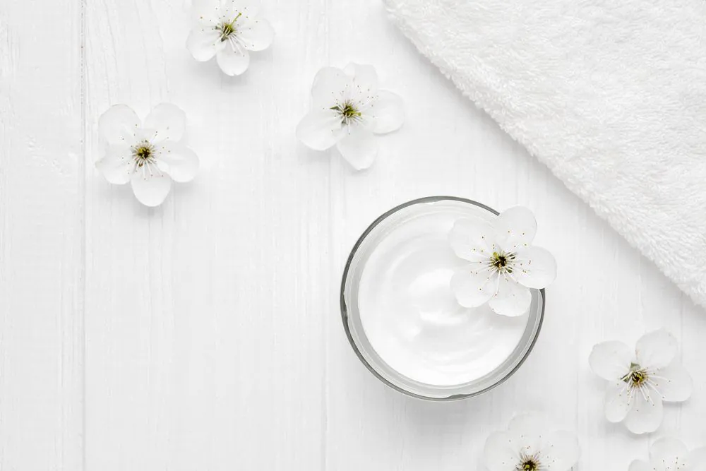 Pflegecreme mit weissen Blüten
